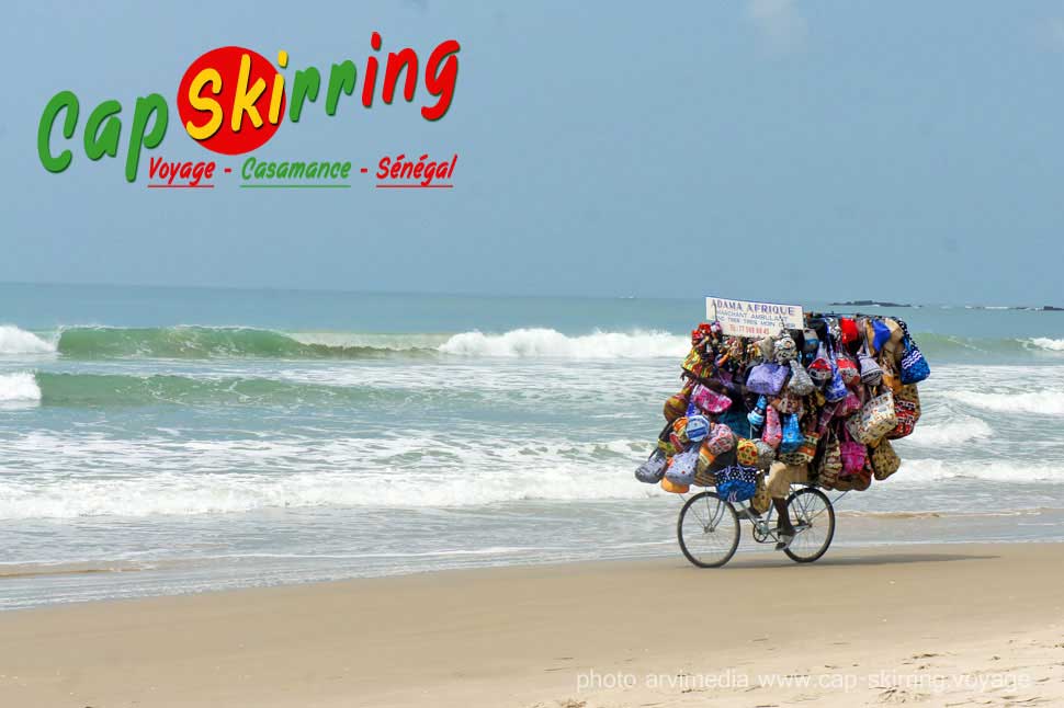 Marchand ambulant en vélo super marché moins cher au Sénégal sur la plage de cap skirring